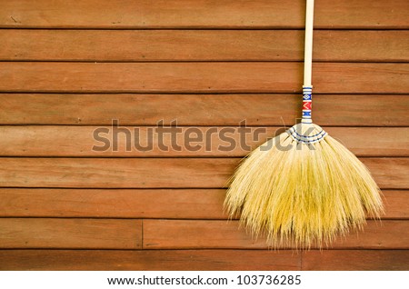 broom hanging on the wooden wall ready for cleaning work
