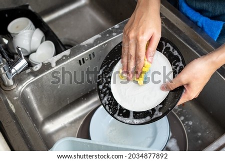 close up shot of dishes being wash by hands of female employee in local restaurant Stock foto © 