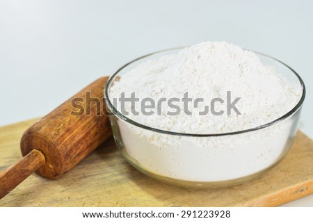 cake flour in glass bowl with wooden roller