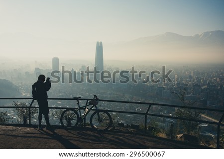 Sport photographer at the top of the hill. Santiago de Chile cityscape.