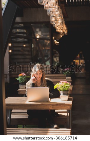 Beautiful woman working on her laptop on a stylish urban restaurant