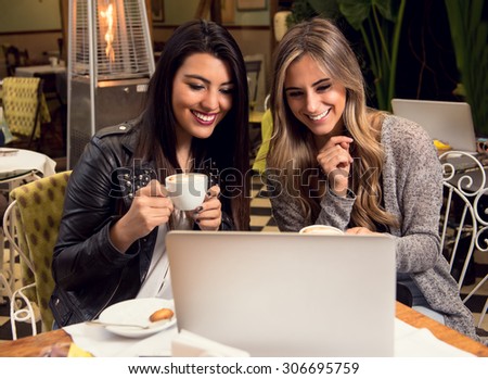 Two girlfriends sharing information while having a coffee