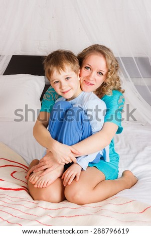 young woman hugging her little son wearing jams