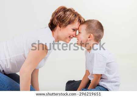 Happy family, little boy and beautiful woman looking at each other, studio shot