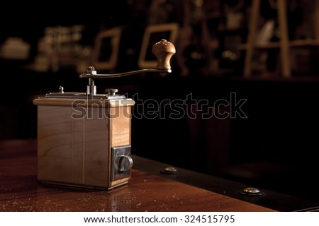Coffee grinder. coffee maker by manual hand grinder on wood table in coffee shop.