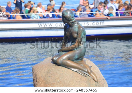 Copenhagen, Denmark - June 30, 2014: Touristic vessel pass near the iconic statue of The Little Mermaid, Copenhagen, Denmark