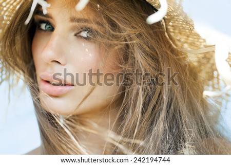 Young woman in straw hat in summer outdoors.