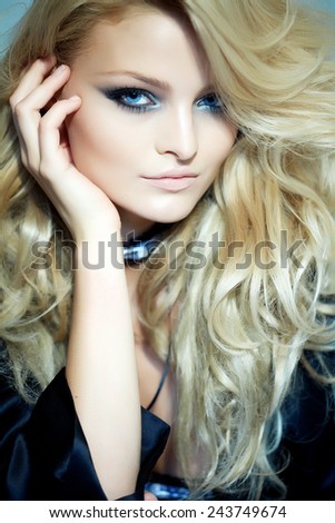 Model with long blond hair posing in black silk robe.