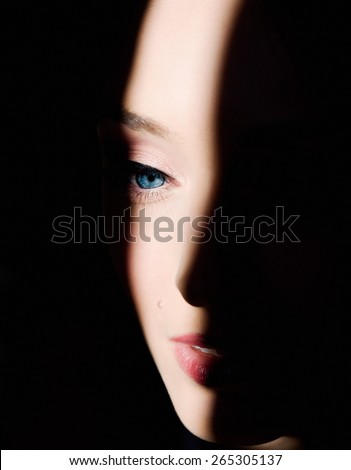 A beautiful woman\'s face in the spot of light.