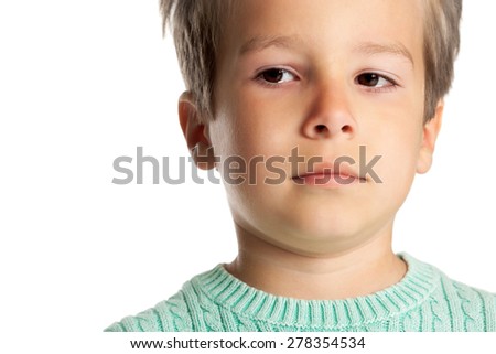 Sad five year old boy posing over white studio background. Closeup of child face in tears.