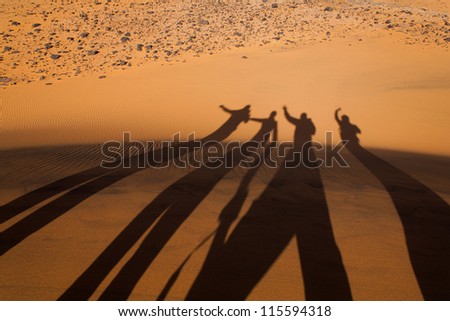 The shadows of people on the sand