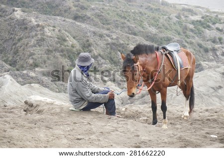 JAVA,INDONESIA-May 25:Unidentified man with the horse for tourist rent at Mount Bromo on May 25,2014 in Java , Indonesia.Mt. Bromo is an active volcano and part of the Tengger massif, in East Java.