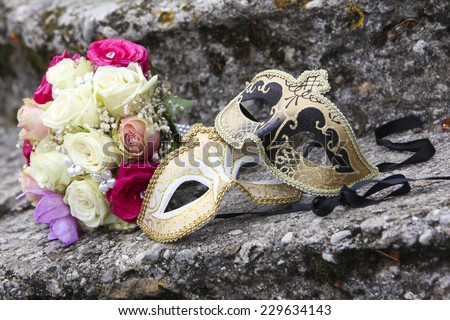 Beautiful wedding bouquet and Venice mask at stone steps