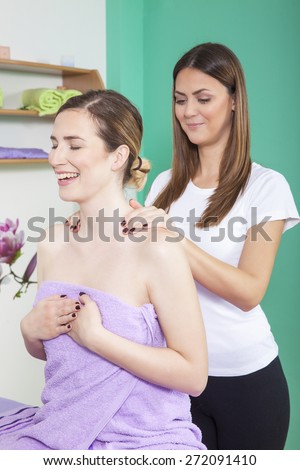 Professional massage therapist massaging a young woman