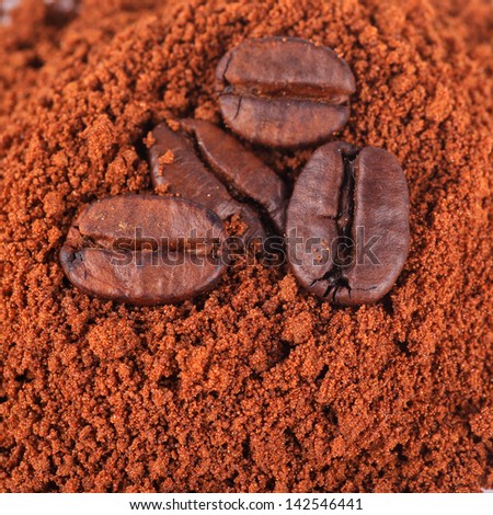 Coffee beans at roasted coffee heap. Coffee bean on macro ground coffee background. ingredient of hot beverage.