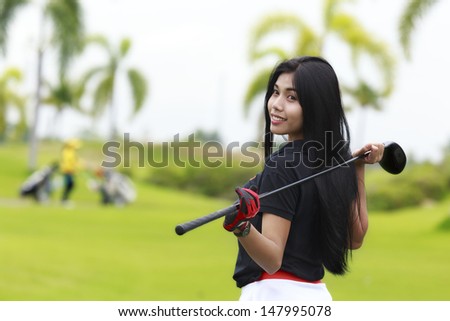 Portrait of Asia woman an elegant woman playing golf on a green
