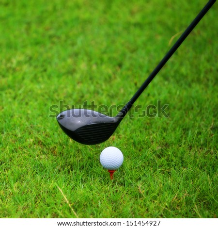 Golf ball behind driver at driving range