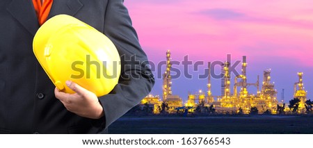 construction engineer with oil plant at dusk