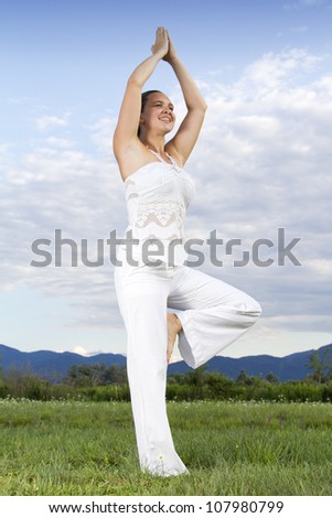 Young attractive brunette girl performing yoga outdoors This photo  is part of a series of various yoga poses by this model.