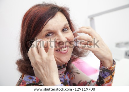 Pleasant mid aged woman showing just applied raw nail extensions