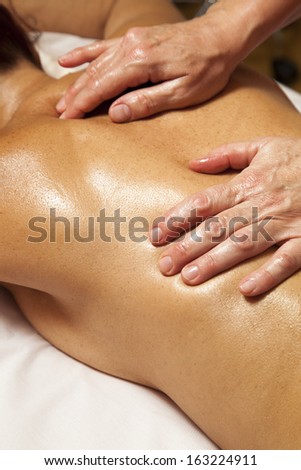 Woman receiving a professional therapeutic massage and lymphatic drainage while lying on a towel in a awarded health massage center,  series of various techniques
