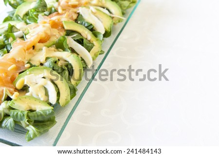 Closeup of healthy salmon salad with avocado and fresh organic Corn salad;  MÃ?Â¢che, Lamb\'s lettuce;  fennel and pignoli, covered  with mustard sauce, selective focus