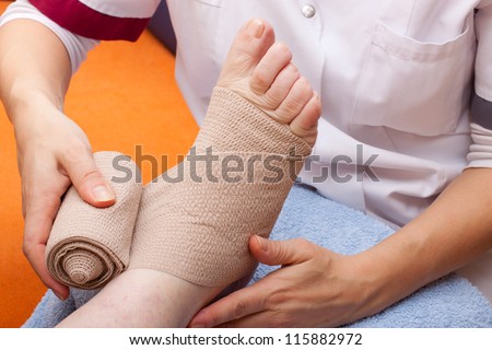 female Doctor bandaged foot of a patient