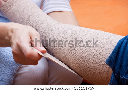 Nurse bandaged the foot of an adult senior