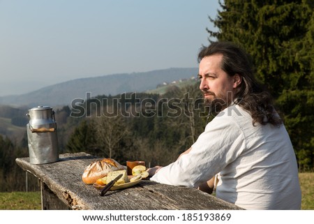 a rustically long-haired man is snacking healthy food