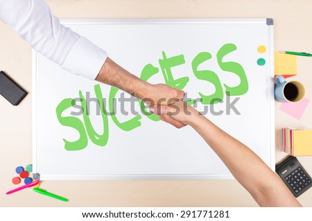 whiteboard with word success, handshake of man and woman