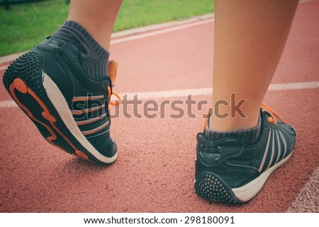 Woman with shoes running on track