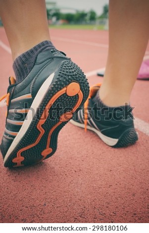 Woman with shoes running on track