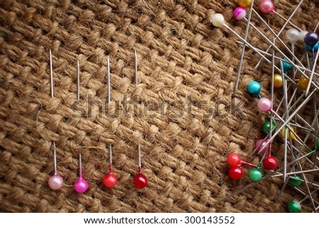 Colorful sewing pins on sackcloth