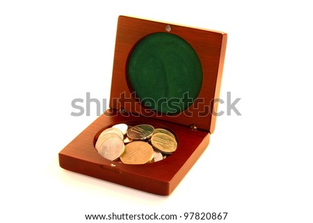 Little wooden box for keeping big money. Vintage brown wooden box filled with romanian coins over white background.