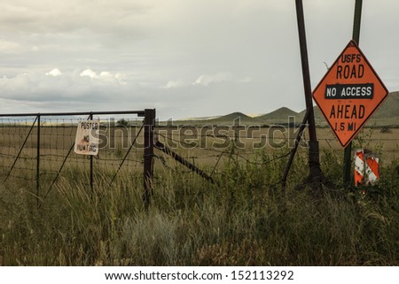 No Hunting and No Access signs along part of Chiricahua foothills of Coronado National Forest in southeastern Arizona, USA/ Do not Enter this Grassland or Road/Summer  green grassland in Arizona