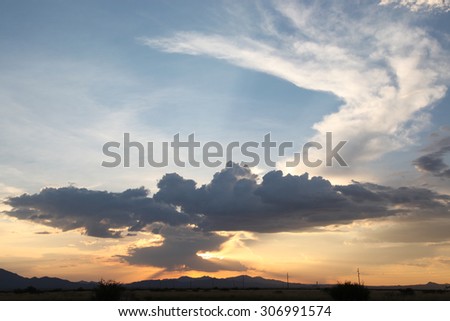 Unusual gray and white cloud formations in blue sky during sunset/Interesting Combination of Gray and White Cloud Shapes in Blue Sky during Sundown/Gray and white cloud formations combined in sky