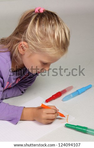 The little girl with blond hair draws