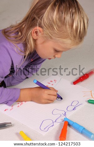 The little girl with blond hair draws
