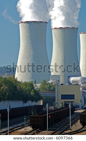 Power plant with supply coal wagons and clouds of white vapour