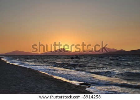 Sun is setting behind the mountains and sea