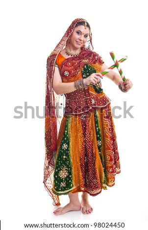 Bollywood dancer in traditional beautiful orange dress with veil and sticks