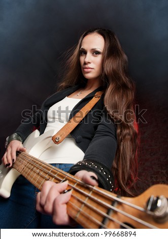 Young beautiful woman playing the guitar on the scene