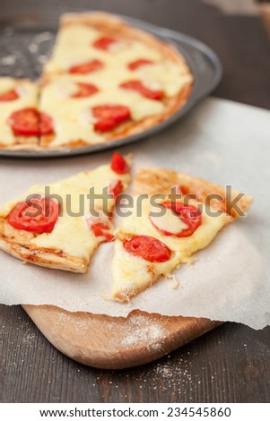 Slice of Italian pizza with mozzarella cheese and tomatoes