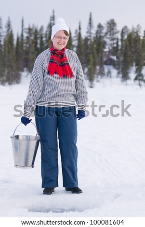 Woman and bucket of household water, behind the ice hole.