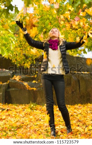 Beautiful girl and falling leaves, autumn color, vertical format