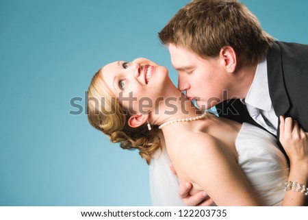 Happy beautiful couple, groom kissing his bride in the neck