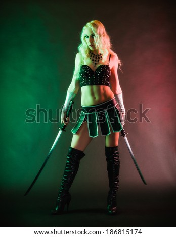 Performer woman wearing sexy costume and holding a samurai sword, grey smoky background