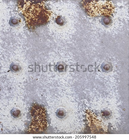 Close up, the rusty steel plate with a nine rivets