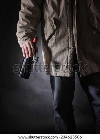 Drunken driver holds a wine bottle and car keys on hand, vertical format