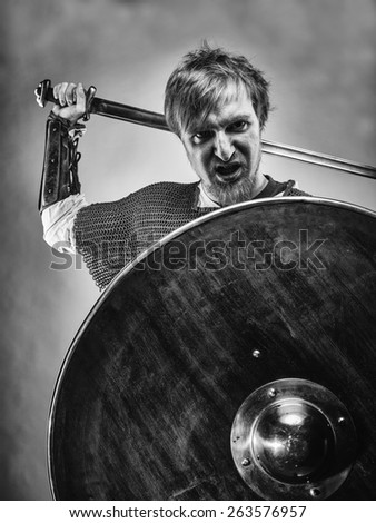 Angry medieval knight armor with a sword and shield, black and white image